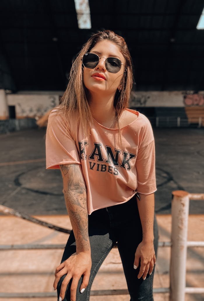 Stylish woman in sunglasses and crew neck T-shirt showcasing street fashion vibe.